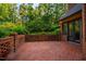Spacious brick patio with brick walls bordering lush landscaping and a home exterior featuring dark trim at 8200 Bromley Rd, Hillsborough, NC 27278