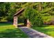 Trail entrance with a wooden structure covered in greenery, inviting exploration at 8200 Bromley Rd, Hillsborough, NC 27278