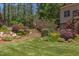 Green backyard with a tiered garden, staircase, landscaping, and trees at 1009 Margarets Ln, Raleigh, NC 27614