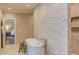 Bright bathroom featuring a freestanding tub, stone accent wall, and access to the main bedroom at 1009 Margarets Ln, Raleigh, NC 27614