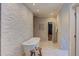 Bright bathroom featuring a freestanding tub, stone accent wall, and access to walk in closet at 1009 Margarets Ln, Raleigh, NC 27614
