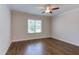 Bright bedroom featuring hardwood floors, a ceiling fan, and a window providing natural light at 1009 Margarets Ln, Raleigh, NC 27614