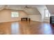 Large bonus room with hardwood floors, desk, and natural light from two windows at 1009 Margarets Ln, Raleigh, NC 27614