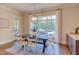 Bright dining room featuring wooden table and chairs, with large window overlooking the backyard at 1009 Margarets Ln, Raleigh, NC 27614