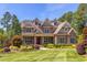 Stunning stone home with manicured lawn, dormer windows, and lush landscaping at 1009 Margarets Ln, Raleigh, NC 27614