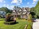 Stately stone home with lush landscaping, well-manicured lawn, and mature trees at 1009 Margarets Ln, Raleigh, NC 27614