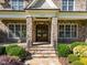 Charming front entrance with stone pillars, a wood door, and well-maintained landscaping at 1009 Margarets Ln, Raleigh, NC 27614