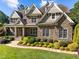 Beautiful stone home with lush landscaping, a manicured lawn, and a welcoming walkway at 1009 Margarets Ln, Raleigh, NC 27614