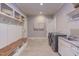 Mud room with gray tile flooring, built in bench, white cabinetry, and coat hooks at 1009 Margarets Ln, Raleigh, NC 27614