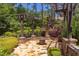 Stone patio with pergola, fire pit and beautifully landscaped with colorful plants and manicured shrubbery at 1009 Margarets Ln, Raleigh, NC 27614