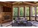 Inviting screened porch with stone fireplace, comfortable seating and wooded views at 1009 Margarets Ln, Raleigh, NC 27614