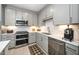 Close-up of a well-equipped kitchen with stainless steel appliances, white tile backsplash, and gray cabinetry at 105 Chatham Walk Ln # 304, Cary, NC 27511