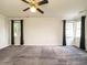 Large bedroom with a ceiling fan, large windows, and neutral walls at 108 S Drawbridge Ln, Cary, NC 27513