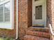 Close up of a front door, showcasing brickwork, steps and window details at 108 S Drawbridge Ln, Cary, NC 27513