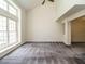Expansive living room with plush carpeting, a high ceiling, and a large window offering natural light at 108 S Drawbridge Ln, Cary, NC 27513