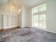 Bright living room with large windows, built-in bookshelf, plush carpeting, and neutral walls at 108 S Drawbridge Ln, Cary, NC 27513