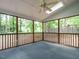 Empty screened porch with wood supports and view to green trees at 108 S Drawbridge Ln, Cary, NC 27513