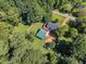 Aerial view showcases a well-kept home with fenced yard, mature trees, and a green roof outbuilding at 109 Mill Creek Dr, Youngsville, NC 27596