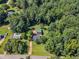 Aerial view of a residential property with long driveway and extensive tree coverage at 109 Mill Creek Dr, Youngsville, NC 27596