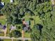 Aerial view features a spacious, verdant lot with mature trees surrounding a well-maintained home and outbuilding at 109 Mill Creek Dr, Youngsville, NC 27596