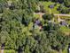 Aerial view of a home with a lush lawn, mature trees, and a convenient outbuilding at 109 Mill Creek Dr, Youngsville, NC 27596