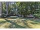 Spacious backyard area with ample green space, mature trees, and a wooden fence at 109 Mill Creek Dr, Youngsville, NC 27596