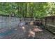 Small, fenced backyard with an AC unit, ladder, and various outdoor items stored at 109 Mill Creek Dr, Youngsville, NC 27596