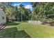 An expansive backyard features mature trees, green grass, and a rustic wood fence at 109 Mill Creek Dr, Youngsville, NC 27596