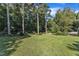 Well-maintained backyard showcasing a lush green lawn and established trees at 109 Mill Creek Dr, Youngsville, NC 27596