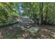Large backyard features a wooden fence and mature trees surrounding a square concrete feature at 109 Mill Creek Dr, Youngsville, NC 27596