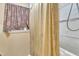 Modest bathroom with a window and a shower and tub combination with a cream and gold shower curtain at 109 Mill Creek Dr, Youngsville, NC 27596