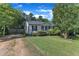 Inviting single-story home with a manicured lawn, gravel driveway, and charming front porch at 109 Mill Creek Dr, Youngsville, NC 27596