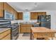 Traditional-style kitchen features wood cabinets, black appliances, and granite countertops at 109 Mill Creek Dr, Youngsville, NC 27596