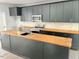 Modern kitchen with butcher block counters, stainless steel appliances, and dark cabinetry at 109 N Dunn St, Angier, NC 27501