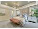 Spacious primary bedroom with a decorative tray ceiling, stylish furnishings, and a cozy seating area at 1204 Sparkling Lake Dr # 20, Apex, NC 27523