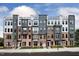 Modern townhome complex with mixed brick and siding, multiple balconies, and well-maintained landscaping at 1250 Coach Station Aly # 201, Raleigh, NC 27601