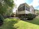 Beautiful backyard featuring a screened porch, wooden deck, lush lawn, mature trees, and a fire pit at 1316 Plunket Dr, Wake Forest, NC 27587