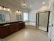 Elegant bathroom featuring dual vanities, soaking tub, glass-enclosed shower and a crystal chandelier at 1316 Plunket Dr, Wake Forest, NC 27587