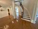 Elegant foyer showcasing a winding staircase with iron railings, hardwood floors, and decorative chandelier lighting at 1316 Plunket Dr, Wake Forest, NC 27587