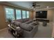 Stylish living room featuring a sectional sofa, large windows, and a decorative ceiling fan at 1316 Plunket Dr, Wake Forest, NC 27587