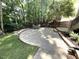 Charming backyard patio featuring a stone firepit and a brick-paved surface surrounded by mature trees at 1316 Plunket Dr, Wake Forest, NC 27587