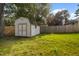 Backyard shed for storage with a fenced perimeter and green lawn at 1401 Burchcrest Dr, Garner, NC 27529