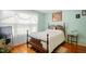 Cozy bedroom with hardwood floors, large windows, and a vintage-style bed at 1401 Burchcrest Dr, Garner, NC 27529