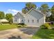 A view of the side of the light-colored home and the driveway with a large green lawn at 1401 Burchcrest Dr, Garner, NC 27529
