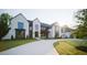 Stunning two-story white brick home with black trim, large windows and a circular driveway at 1620 Hunting Ridge Rd, Raleigh, NC 27615