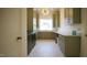 Well-appointed laundry room featuring olive green cabinetry, ample counter space, and modern appliances at 1620 Hunting Ridge Rd, Raleigh, NC 27615