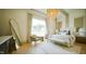 Bright main bedroom with a statement chandelier, large windows and sitting area, providing a luxurious retreat at 1620 Hunting Ridge Rd, Raleigh, NC 27615