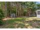 Backyard featuring mature trees and an outdoor storage shed, enhancing functionality. Space is private and well maintained at 170 Lothian, Rocky Mount, NC 27804