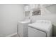 This laundry room includes a washer, dryer, storage shelves, and vinyl flooring at 170 Lothian, Rocky Mount, NC 27804