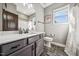 Bathroom featuring gray vanity, mirror and window with natural lighting at 178 Greenwich Dr, Sanford, NC 27330